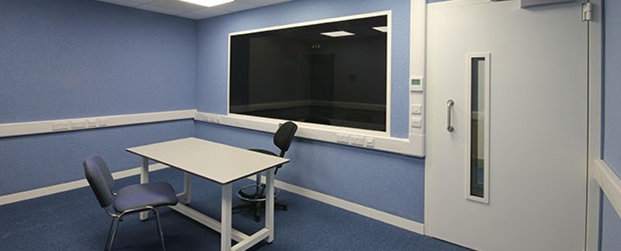 Ljudisolerat rum för förhör, med bord och stolar